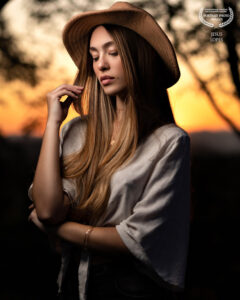Mulher de chapéu ao pôr do sol. Foto de Jesus Lopes premiada no International Portrait Photography Contest