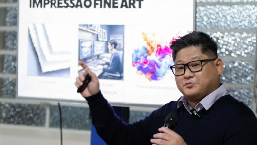 Homem palestrando com microfone em frente a uma tela com o título Impressão Fine Art