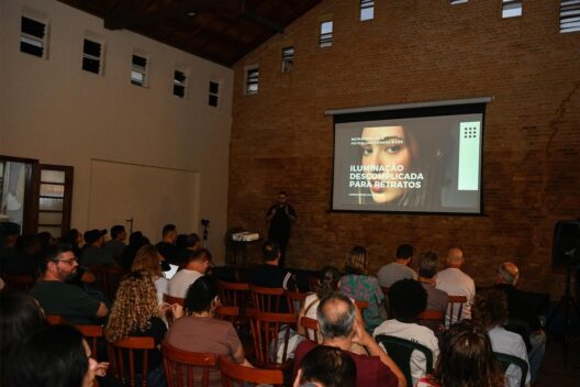 Público assiste à palestra Iluminação Descomplicada para Retratos em um auditório com paredes de tijolos