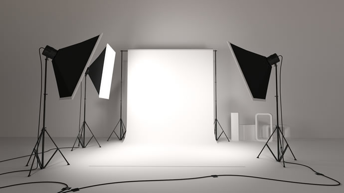 Estúdio de fotografia com fundo branco e três luzes softbox em tripés