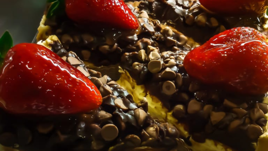 Fatias de torta de chocolate cobertas com gotas de chocolate e morangos inteiros